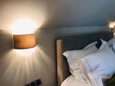 a bedroom with a bed with white pillows and a lamp at Alpina Luxury Chalets in Banya