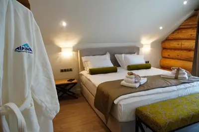 a hotel room with two beds with towels on them at Alpina Luxury Chalets in Banya