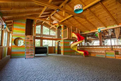 a play room with a slide in a building with a playground at Бунгала Сън Сити in Sandanski