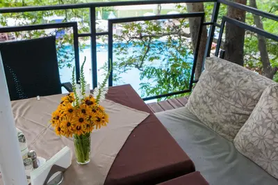 a table with a vase of flowers on a balcony at Бунгала Сън Сити in Sandanski
