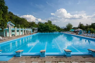 a large swimming pool with blue water at Бунгала Сън Сити in Sandanski