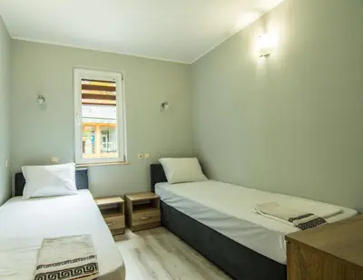 a small room with two beds and a window at Бунгала Сън Сити in Sandanski
