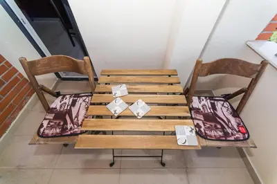 a wooden table and two chairs with cushions at Alma Apartment - Stylish 1BD Flat with Balcony by Flat Mаnager in Plovdiv