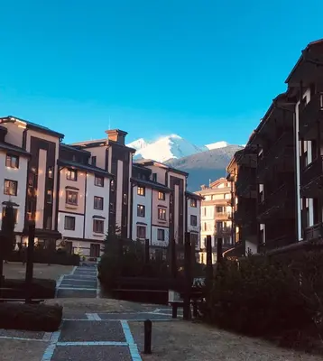 a group of buildings with a mountain in the background at Luxury Downtown Apartment - Gondola in Bansko