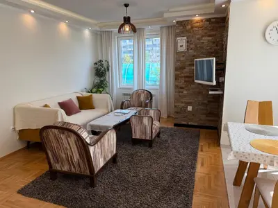 a living room with a couch and chairs and a tv at Valentina Bg Apartment in Sofia