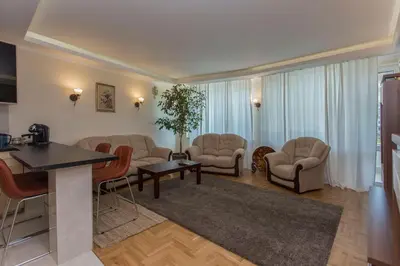 a large living room with chairs and a table at Apartment 