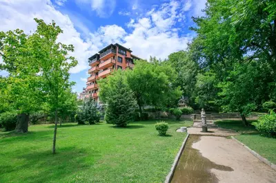 a park with a building in the background at The Sun loves You - right beside the Park! in Sandanski