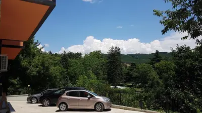 a couple of cars parked in a parking lot at The Sun loves You - right beside the Park! in Sandanski