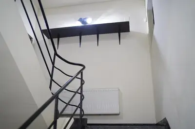 a staircase in a white room with a light on the wall at Hostel Plovdiv in Plovdiv