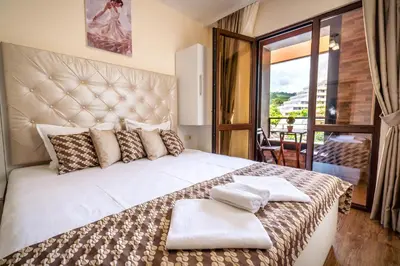 a bedroom with a large bed and a balcony at Park Apartment Emilin in Sandanski