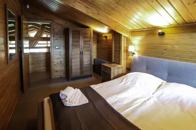 a bedroom with a bed in a wooden room at Mountain Hawk Park in Bansko