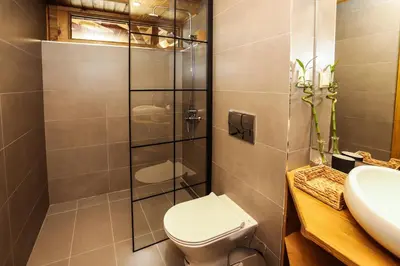 a bathroom with a toilet and a glass shower at Mountain Hawk Park in Bansko