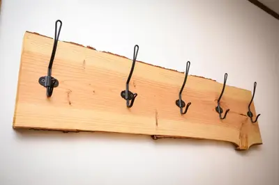 a wooden plank with four hooks on a wall at Родопчани Старцево in Starzewo