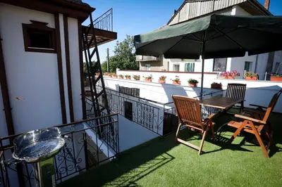 a balcony with a table and an umbrella at Родопчани Старцево in Starzewo
