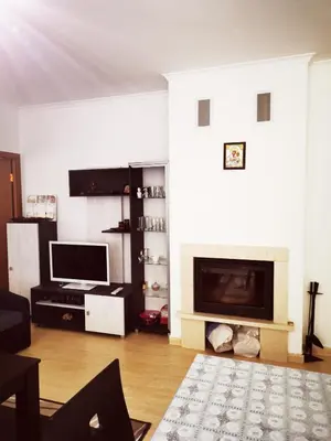 a living room with a fireplace and a television at Private Apartment in Grand Monastery in Pamporovo