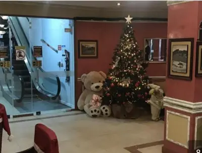 a teddy bear sitting next to a christmas tree at Private Apartment in Grand Monastery in Pamporovo