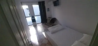 a small white room with a bed and a window at ПАИ Хост in Plovdiv