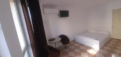a small white room with a bed and a table at ПАИ Хост in Plovdiv