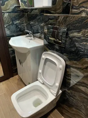 a bathroom with a white toilet and a sink at Патилови in Sandanski