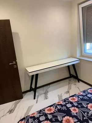 a bedroom with a bed with a bench on it at Патилови in Sandanski