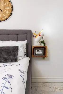 a bedroom with a bed and a clock on the wall at Stylish 1BD Flat with a terrace near the centre of Plovdiv by Flat Mаnager in Plovdiv