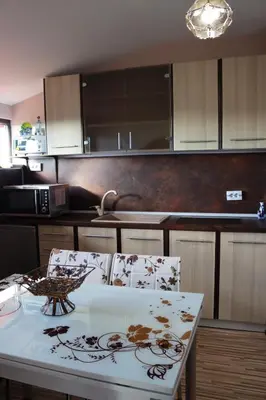 a kitchen with a table and two chairs in it at GREEN HOUSE - Попниколови in Sapareva Banya