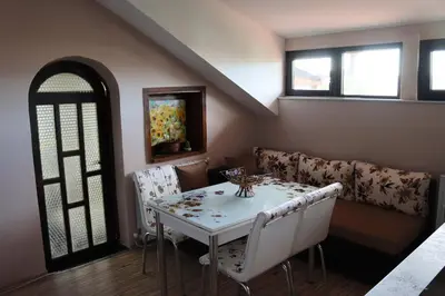 a dining room with a white table and chairs at GREEN HOUSE - Попниколови in Sapareva Banya