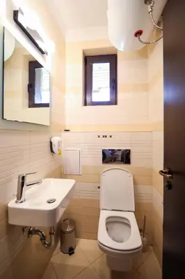 a bathroom with a white toilet and a sink at Lake View House in Bansko