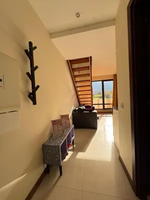 a living room with a chair and a stair case at Sunny Duplex, Mountain Views, Spa Access, Near Bansko, Terra Complex in Razlog