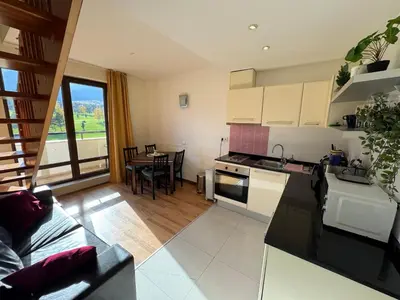 a kitchen and a living room with a table at Sunny Duplex, Mountain Views, Spa Access, Near Bansko, Terra Complex in Razlog