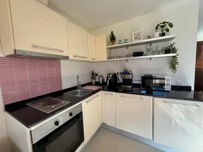 a kitchen with white cabinets and black counter tops at Sunny Duplex, Mountain Views, Spa Access, Near Bansko, Terra Complex in Razlog
