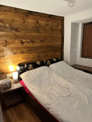 a bed in a bedroom with a wooden wall at Къща за гости Виевци in Vievo