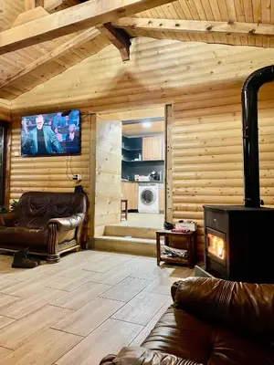 a living room with leather furniture and a flat screen tv at Къща за гости Виевци in Vievo