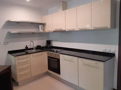 a kitchen with white cabinets and a black counter top at Apartments B06 in TERRA complex in Razlog
