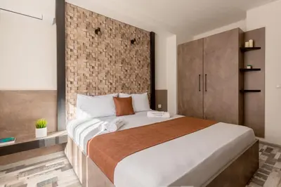 a bedroom with a large bed and a brick wall at ОРФЕЕВИТЕ ПЕСНИ in Devin