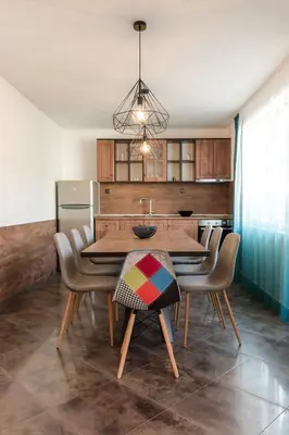 a kitchen with a wooden table with chairs and a dining room at ОРФЕЕВИТЕ ПЕСНИ in Devin
