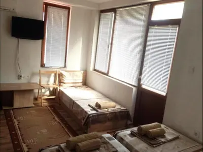 a room with two beds in a room with windows at Роден Край Homeland in Sopot