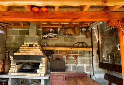 an outdoor kitchen with a fireplace in a house at Роден Край Homeland in Sopot