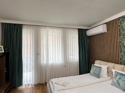 a hotel room with two beds and a window at Vega Apartment in Velingrad