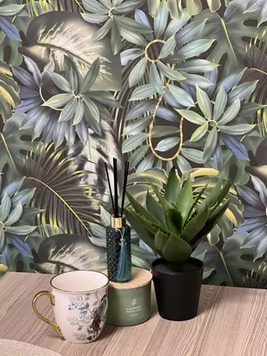 a table with two plants and a wall with flowers at Vega Apartment in Velingrad