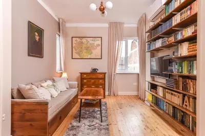 a living room with a couch and bookshelves at Chez Marie - Cozy One-Bedroom with Balcony by Flat Mаnager in Sofia
