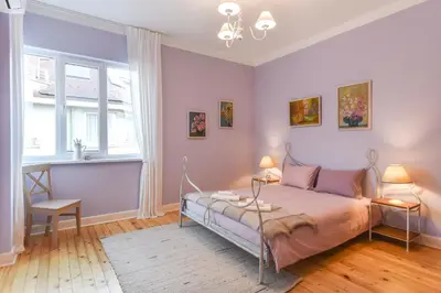 a bedroom with pink walls and a bed with two lamps at Chez Marie - Cozy One-Bedroom with Balcony by Flat Mаnager in Sofia