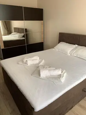 a bed with white sheets and towels on it at CENTER APARTMENT PLOVDIV in Plovdiv
