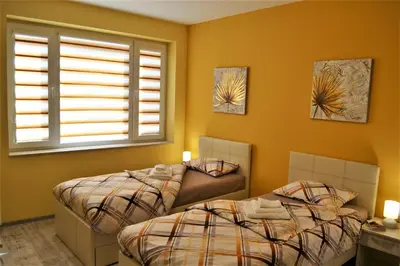 two beds in a room with two windows at Guest Apartment Balkan in Karlovo