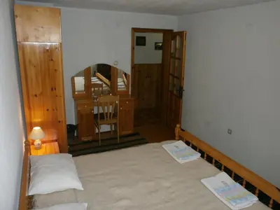 a room with a bed and a table and a mirror at Къща за гости Каневи in Momchilovtsi