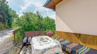 a table sitting on the side of a building at Къща за гости Каневи in Momchilovtsi