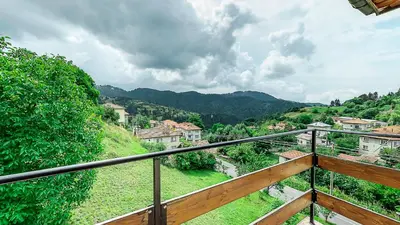 a balcony with a view of a village at Къща за гости Каневи in Momchilovtsi