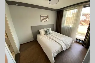 a bedroom with a bed with white sheets and a window at LUX 1BD/1BA City Center Apartment in Blagoevgrad