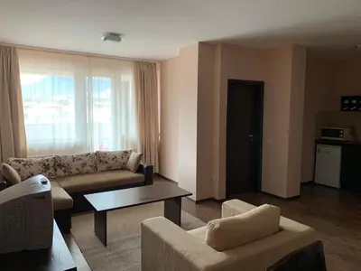 a living room with a couch and a table at Апартамент в комплекс Bansko Royal Towers in Bansko