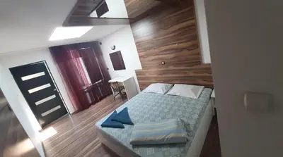 a small bedroom with a bed and a wooden wall at Hostel Pop Bogomil in Sofia